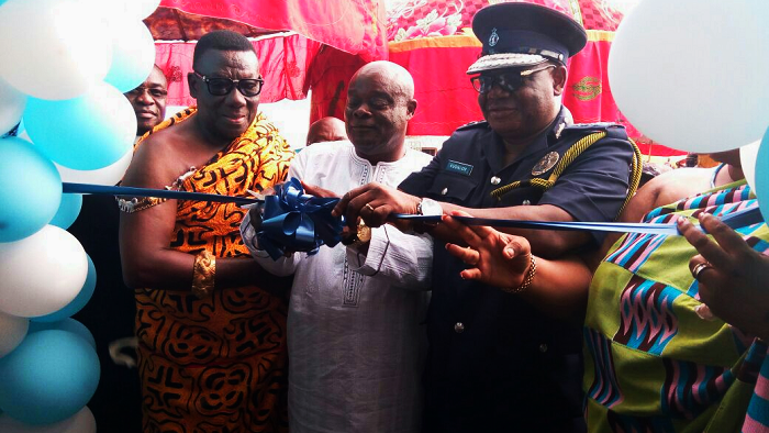 Mr John Kudalor (right), the Inspector-General of Police, being assisted by the Mamponghene, Daasebre Osei Bonsu II, and Mr Yaw Amponsah Marfo (middle), the Chief Executive Officer of Yesu Dea Transport, to cut the tape to inaugurate the police station. Below is the front view of the police station.